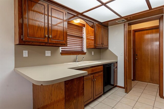 3116 SW 96th St, Oklahoma City, OK 73159 - kitchen featuring black dishwasher, light countertops, light tile patterned flooring, a peninsula, and brown cabinets