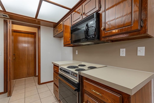 3116 SW 96th St, Oklahoma City, OK 73159 - kitchen featuring range with electric stovetop, black microwave, light countertops, and light tile patterned floors