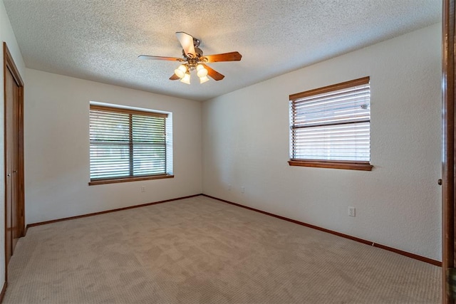 3116 SW 96th St, Oklahoma City, OK 73159 - unfurnished bedroom with a closet, multiple windows, light carpet, a textured ceiling, and a ceiling fan