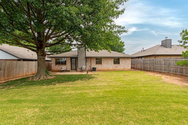 3116 SW 96th St, Oklahoma City, OK 73159 - rear view of house with a patio, brick siding, a fenced backyard, and roof with shingles