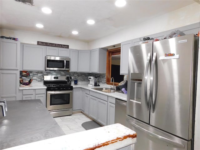 2236 Highland Rd, Oklahoma City, OK 73110 - kitchen featuring appliances with stainless steel finishes, light marble finish flooring, gray cabinetry, decorative backsplash, and recessed lighting