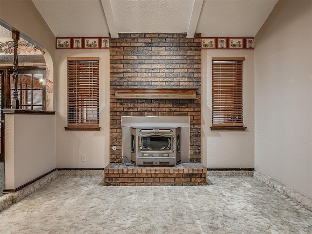 924 Penn Ln, Moore, OK 73160 - unfurnished living room featuring carpet, beam ceiling, a wood stove, and a textured ceiling