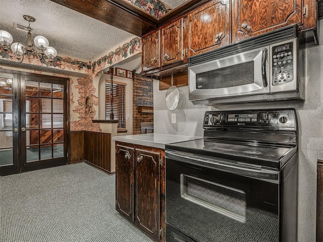 924 Penn Ln, Moore, OK 73160 - kitchen with black electric range, stainless steel microwave, a textured ceiling, arched walkways, and light countertops