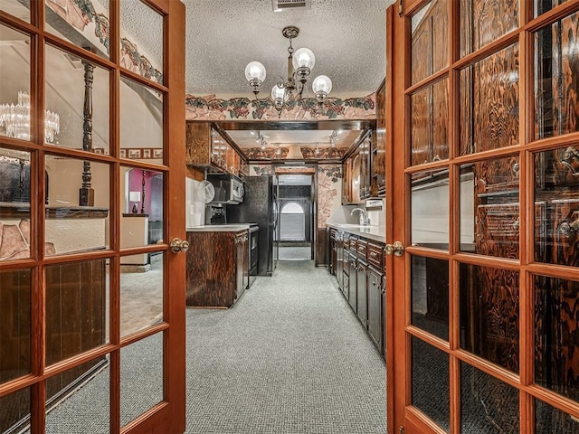 924 Penn Ln, Moore, OK 73160 - bar featuring light carpet, stainless steel microwave, a chandelier, and a textured ceiling
