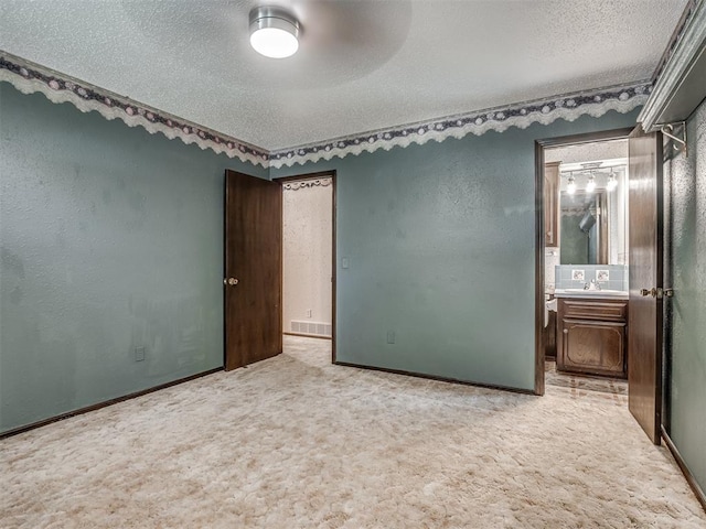924 Penn Ln, Moore, OK 73160 - unfurnished bedroom with a textured ceiling, carpet flooring, and ensuite bath