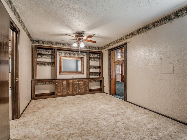 924 Penn Ln, Moore, OK 73160 - empty room featuring a textured wall, a textured ceiling, ceiling fan, carpet flooring, and electric panel