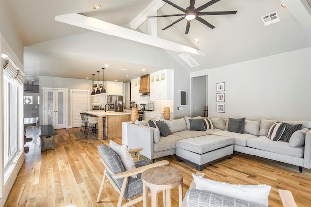 833 Gathering Leaves Way Unit 9183810100, Edmond, OK 73034 - living room featuring ceiling fan, high vaulted ceiling, light wood-style floors, beamed ceiling, and plenty of natural light