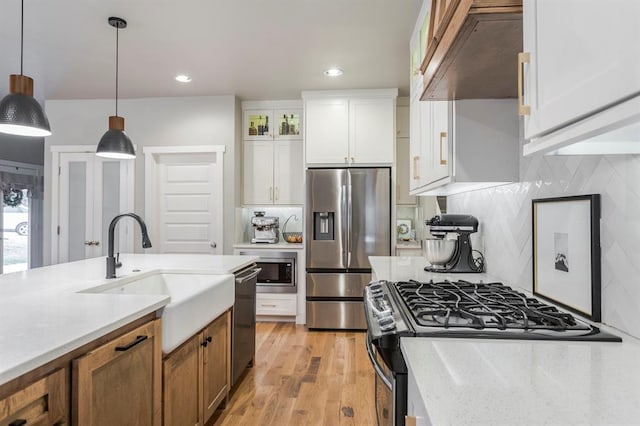 833 Gathering Leaves Way Unit 9183810100, Edmond, OK 73034 - kitchen with appliances with stainless steel finishes, custom exhaust hood, white cabinetry, pendant lighting, and brown cabinets