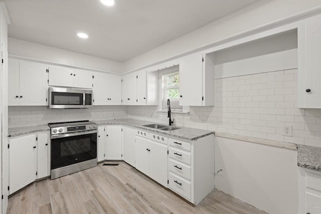 2525 NW 32nd St, Oklahoma City, OK 73112 - kitchen with stainless steel appliances, light stone countertops, white cabinetry, and recessed lighting