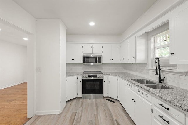 2525 NW 32nd St, Oklahoma City, OK 73112 - kitchen featuring stainless steel appliances, light wood-type flooring, decorative backsplash, white cabinets, and recessed lighting