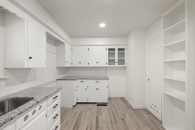 2525 NW 32nd St, Oklahoma City, OK 73112 - kitchen with light stone counters, white cabinets, light wood finished floors, decorative backsplash, and recessed lighting
