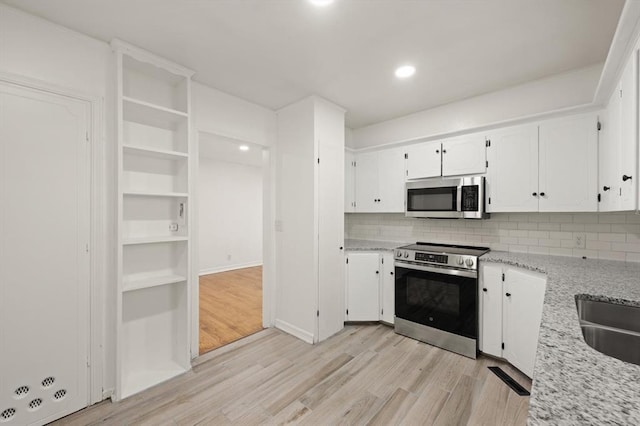 2525 NW 32nd St, Oklahoma City, OK 73112 - kitchen with stainless steel appliances, white cabinetry, backsplash, light wood-type flooring, and recessed lighting