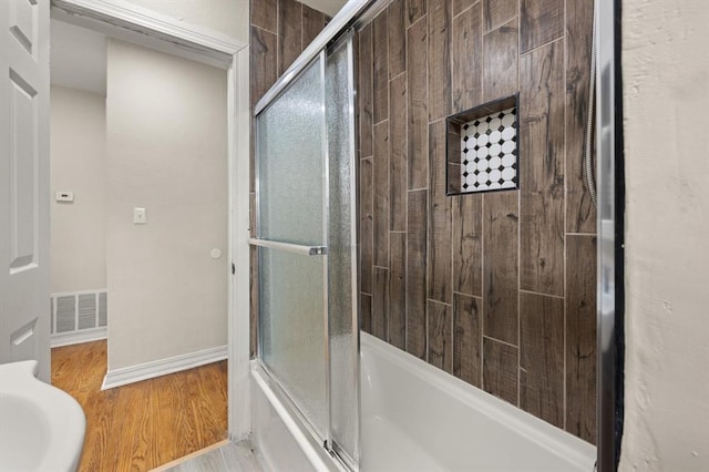 2525 NW 32nd St, Oklahoma City, OK 73112 - bathroom featuring bath / shower combo with glass door and wood finished floors