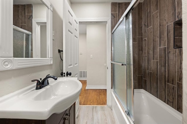 2525 NW 32nd St, Oklahoma City, OK 73112 - bathroom featuring vanity, enclosed tub / shower combo, and wood finished floors