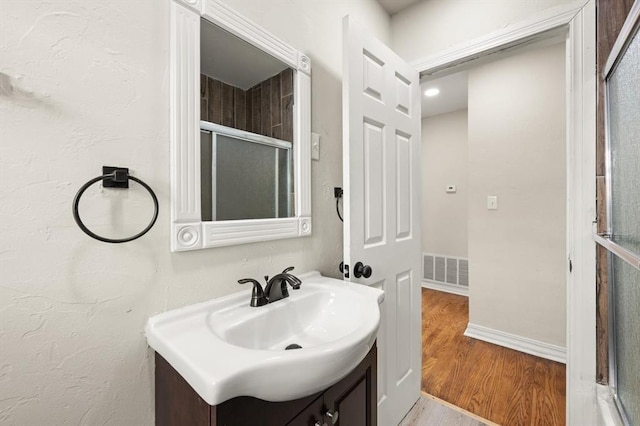 2525 NW 32nd St, Oklahoma City, OK 73112 - bathroom featuring vanity, wood finished floors, and an enclosed shower