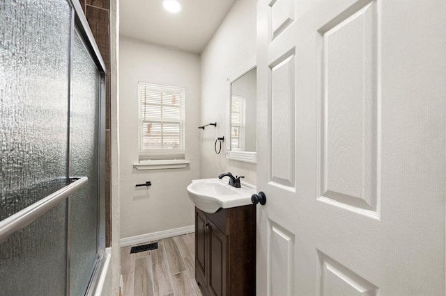 2525 NW 32nd St, Oklahoma City, OK 73112 - full bathroom with vanity, a shower with door, and wood finished floors