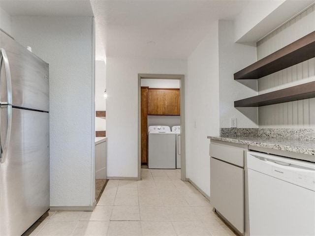 1404 Mary Lee Ln, Edmond, OK 73034 - kitchen with white dishwasher, freestanding refrigerator, open shelves, independent washer and dryer, and light stone countertops