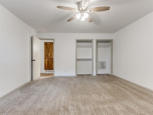 1404 Mary Lee Ln, Edmond, OK 73034 - unfurnished bedroom with light colored carpet, multiple closets, a textured ceiling, and a ceiling fan