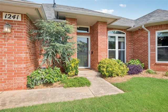 1241 NW 183rd St, Edmond, OK 73012 - doorway to property with brick siding, roof with shingles, and a yard