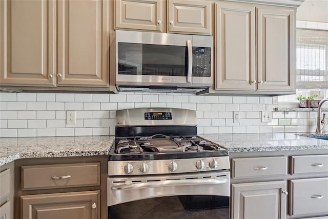1241 NW 183rd St, Edmond, OK 73012 - kitchen with appliances with stainless steel finishes, backsplash, and light stone countertops