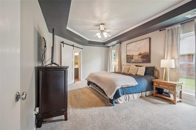 1241 NW 183rd St, Edmond, OK 73012 - carpeted bedroom featuring a barn door, ornamental molding, a tray ceiling, ceiling fan, and connected bathroom