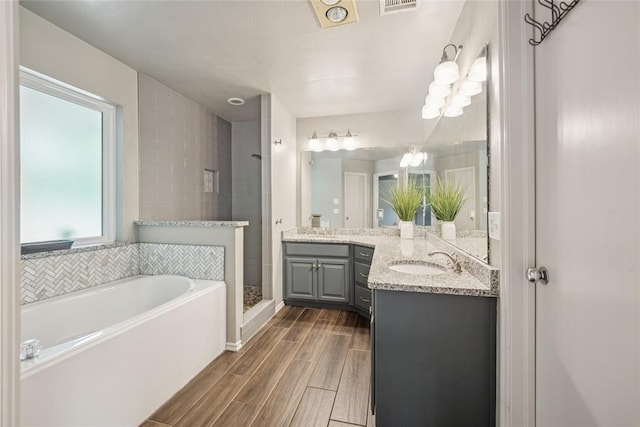 1241 NW 183rd St, Edmond, OK 73012 - full bath with vanity, a bath, a shower stall, and wood finish floors