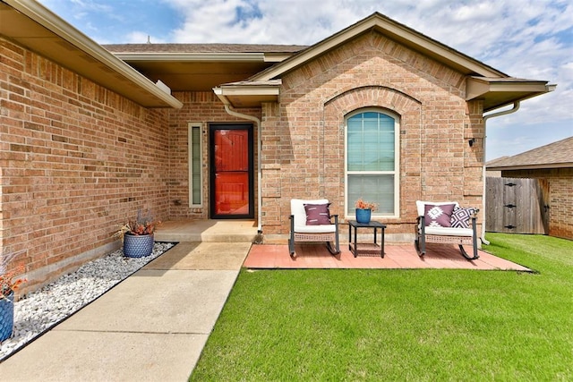 9909 Summerhill Ln, Yukon, OK 73099 - property entrance featuring brick siding, a yard, a gate, and a patio area