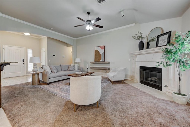 9909 Summerhill Ln, Yukon, OK 73099 - carpeted living area featuring a tiled fireplace, tile patterned floors, a ceiling fan, and ornamental molding