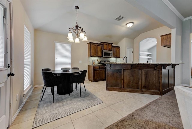 9909 Summerhill Ln, Yukon, OK 73099 - dining area featuring a chandelier, healthy amount of natural light, vaulted ceiling, and light tile patterned floors
