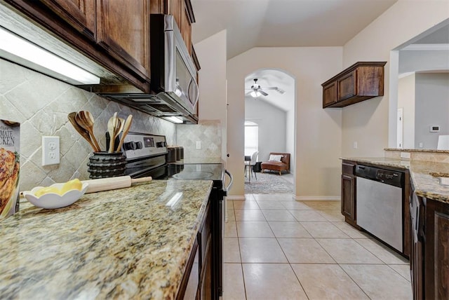9909 Summerhill Ln, Yukon, OK 73099 - kitchen with appliances with stainless steel finishes, arched walkways, vaulted ceiling, ceiling fan, and light stone countertops