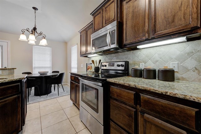 9909 Summerhill Ln, Yukon, OK 73099 - kitchen featuring appliances with stainless steel finishes, backsplash, light stone countertops, pendant lighting, and dark brown cabinetry