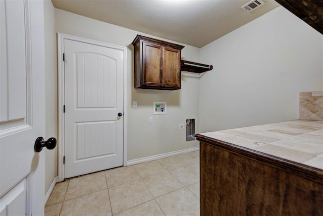 9909 Summerhill Ln, Yukon, OK 73099 - laundry area with hookup for an electric dryer, hookup for a washing machine, cabinet space, and light tile patterned floors