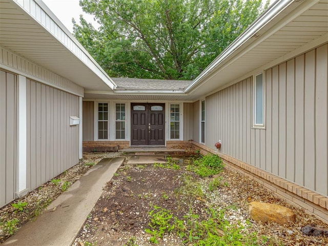 3700 N Edgewater Dr, Oklahoma City, OK 73116 - view of exterior entry featuring a shingled roof, brick siding, and board and batten siding