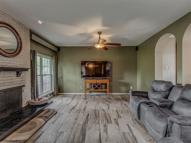 3700 N Edgewater Dr, Oklahoma City, OK 73116 - living room featuring arched walkways, ceiling fan, wood finished floors, and a brick fireplace