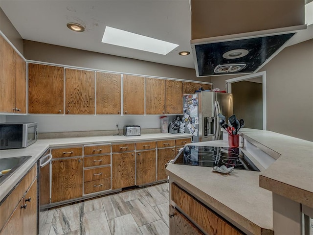 3700 N Edgewater Dr, Oklahoma City, OK 73116 - kitchen featuring stainless steel appliances, a skylight, light countertops, and brown cabinetry