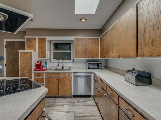 3700 N Edgewater Dr, Oklahoma City, OK 73116 - kitchen featuring stainless steel appliances, a skylight, light countertops, and brown cabinetry