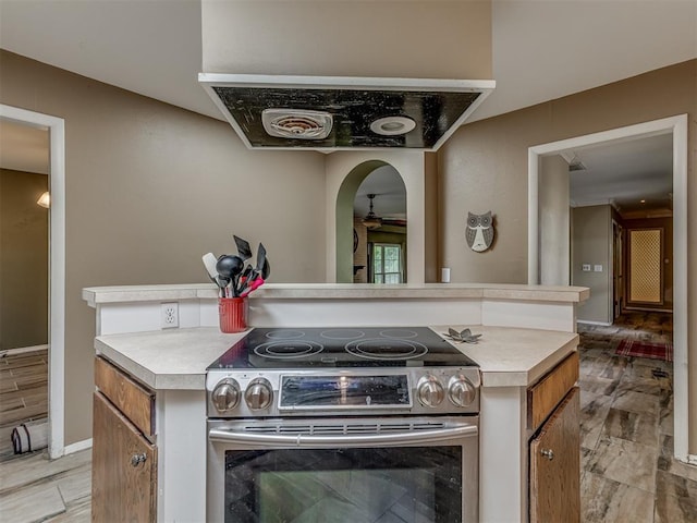 3700 N Edgewater Dr, Oklahoma City, OK 73116 - kitchen featuring stainless steel electric range oven, light countertops, brown cabinets, and ceiling fan