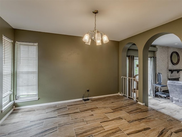 3700 N Edgewater Dr, Oklahoma City, OK 73116 - empty room featuring arched walkways, a chandelier, and wood finish floors