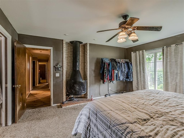 3700 N Edgewater Dr, Oklahoma City, OK 73116 - bedroom with carpet floors, a wood stove, and a ceiling fan