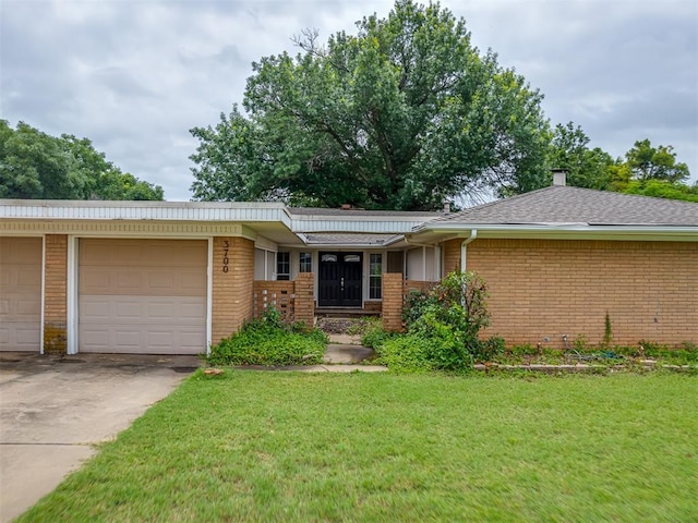 3700 N Edgewater Dr, Oklahoma City, OK 73116 - ranch-style house with brick siding, a front yard, a garage, and concrete driveway