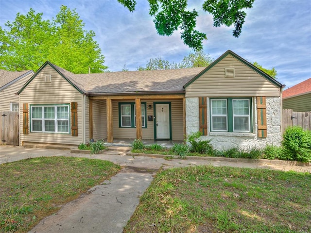 531 NW 48th St, Oklahoma City, OK 73118 - view of front of property with covered porch, stone siding, and a shingled roof