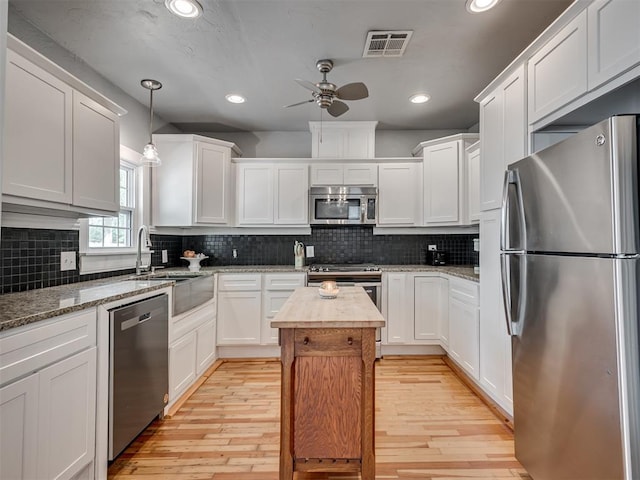 531 NW 48th St, Oklahoma City, OK 73118 - kitchen with stainless steel appliances, ceiling fan, white cabinetry, butcher block counters, and light wood-style flooring