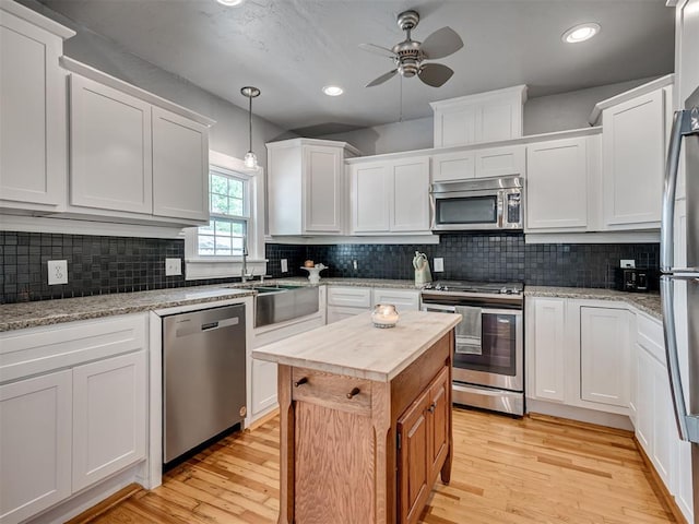 531 NW 48th St, Oklahoma City, OK 73118 - kitchen with appliances with stainless steel finishes, butcher block countertops, ceiling fan, light wood-type flooring, and recessed lighting