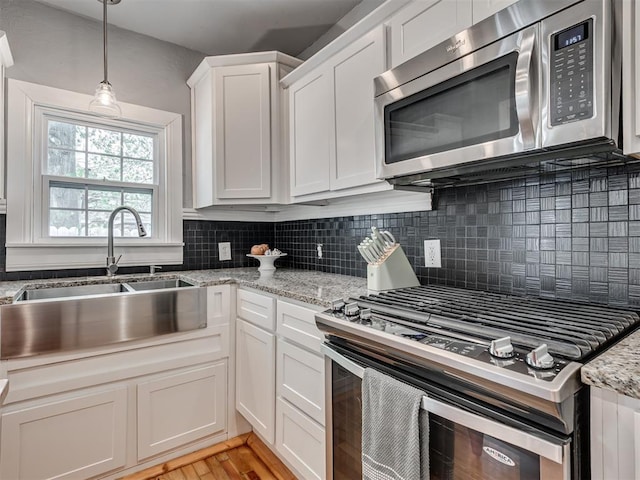 531 NW 48th St, Oklahoma City, OK 73118 - kitchen featuring stainless steel appliances, tasteful backsplash, white cabinetry, hanging light fixtures, and light stone countertops