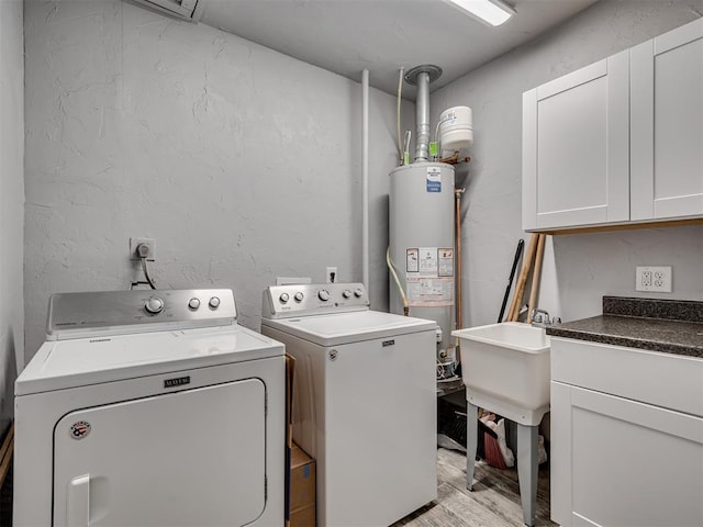 531 NW 48th St, Oklahoma City, OK 73118 - laundry room with washing machine and clothes dryer, water heater, light wood finished floors, cabinet space, and a textured wall