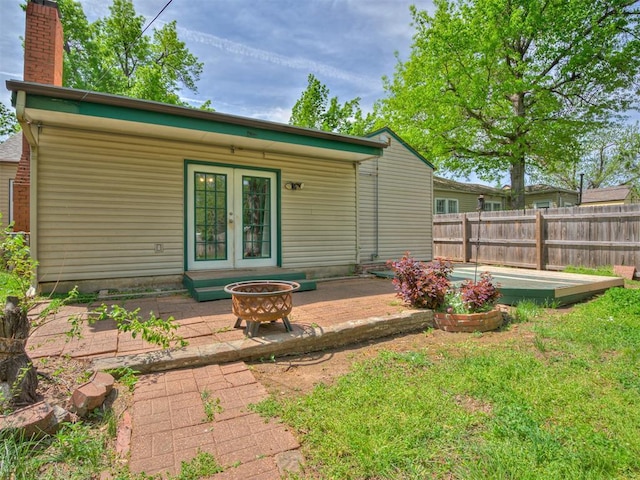 531 NW 48th St, Oklahoma City, OK 73118 - back of house featuring french doors, a patio, a chimney, and a fire pit