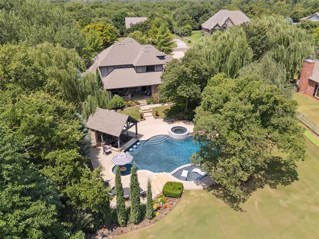 5710 Smoky Hill Trl, Edmond, OK 73034 - aerial view of property and surrounding area with a pool area and a heavily wooded area