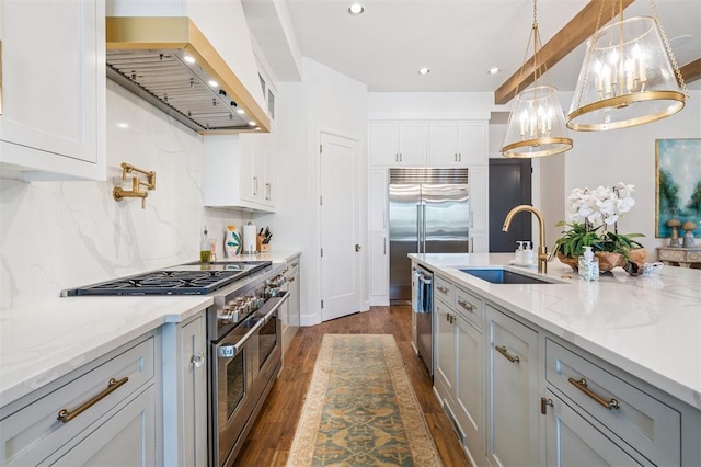1415 Sherwood Ln, Nichols Hills, OK 73116 - kitchen featuring high end appliances, exhaust hood, dark wood finished floors, backsplash, and decorative light fixtures