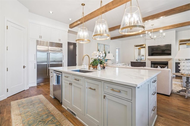 1415 Sherwood Ln, Nichols Hills, OK 73116 - kitchen with stainless steel appliances, beamed ceiling, open floor plan, a center island with sink, and dark wood-style flooring