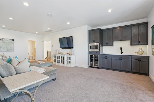 1415 Sherwood Ln, Nichols Hills, OK 73116 - living area with beverage cooler, light carpet, recessed lighting, and bar with sink